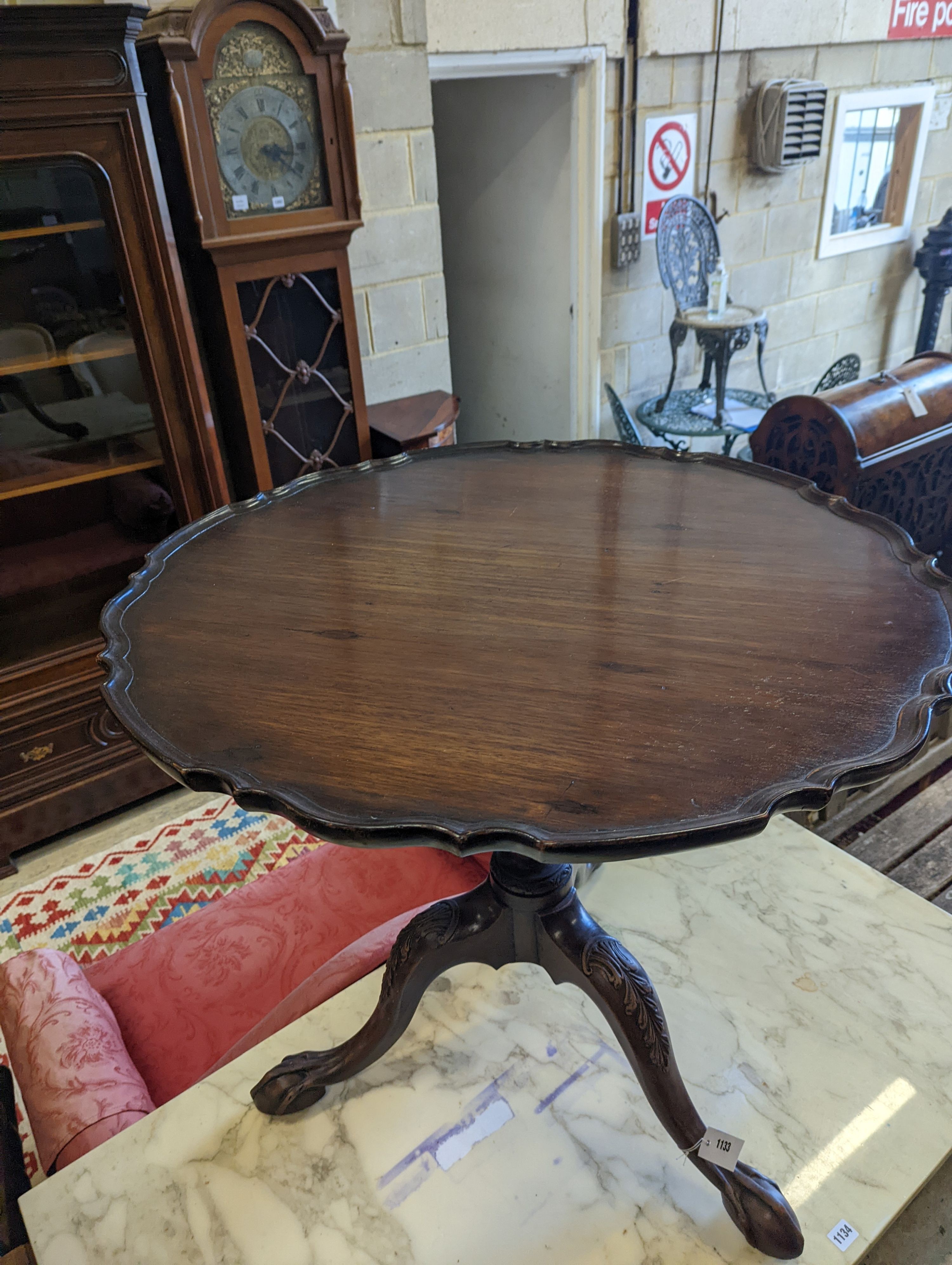 A George III style circular mahogany tripod table, with piecrust top and claw and ball feet, diameter 75cm, height 70cm